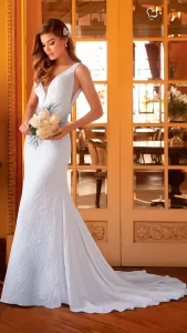 Mulher segurando um bouquet com olhar declinando para baixo, utilizando um vestido de noiva sereia simples e elegante.